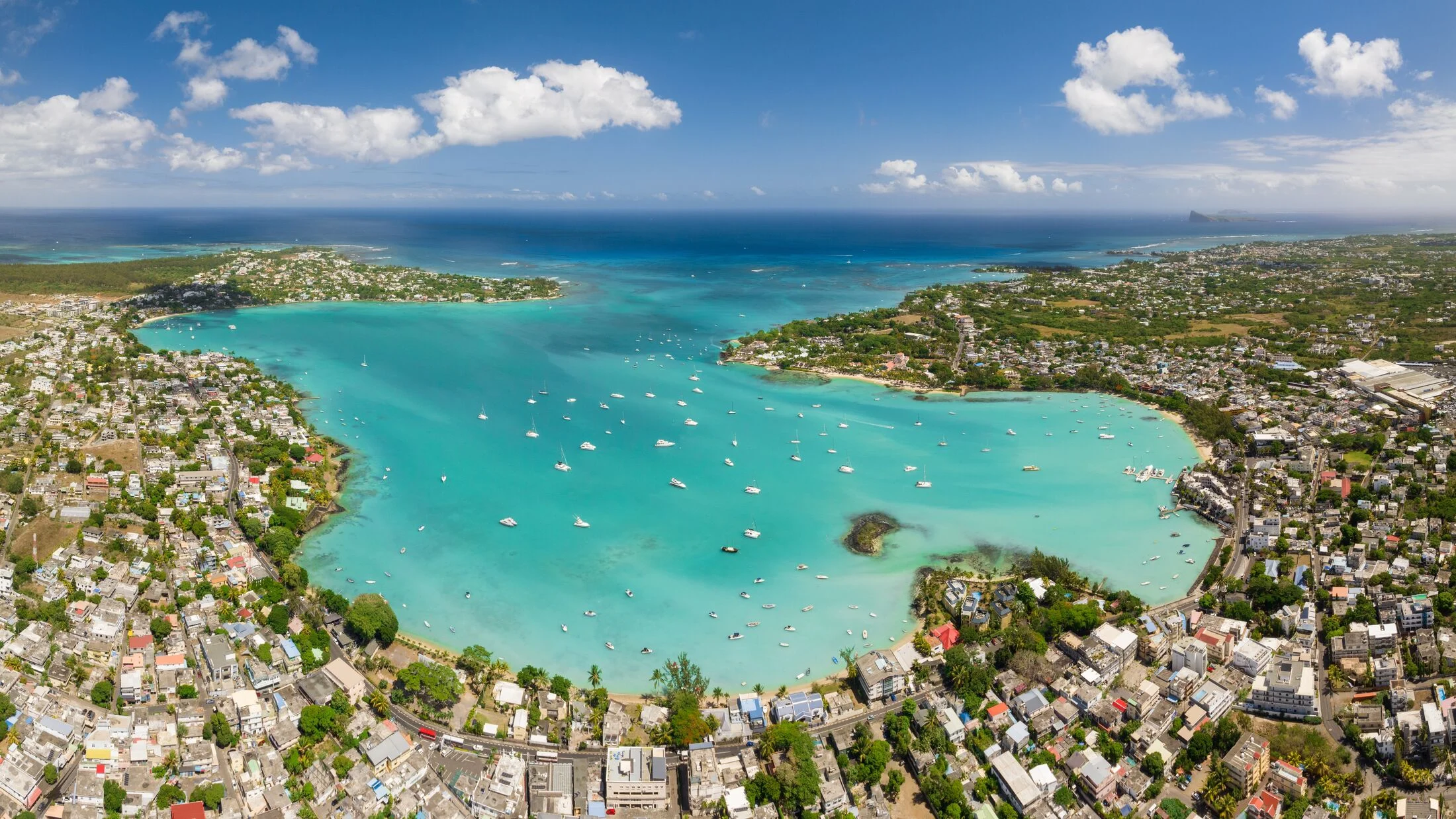 Aerial view of Grand Baie's turquoise bay lined with yachts, the vibrant seaside town of northern Mauritius